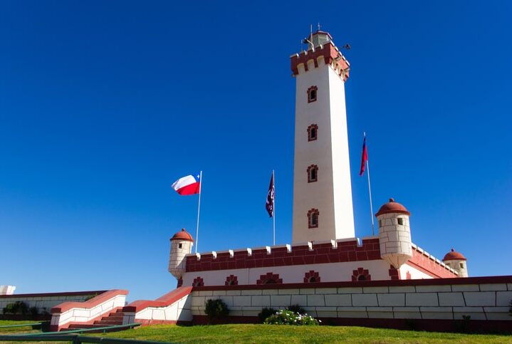 Splendid view of La Serena lighthouse on sunny day and Chilean flags blowing in the wind, Chile. South America iconic landmark