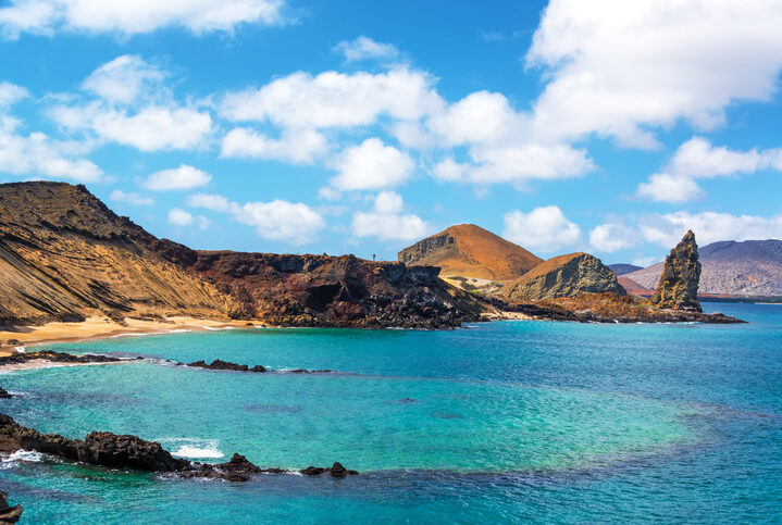 View of an underwater crater in the foreground with Pinnacle Rock in the background on Bartolome Island in the Galapagos Islands