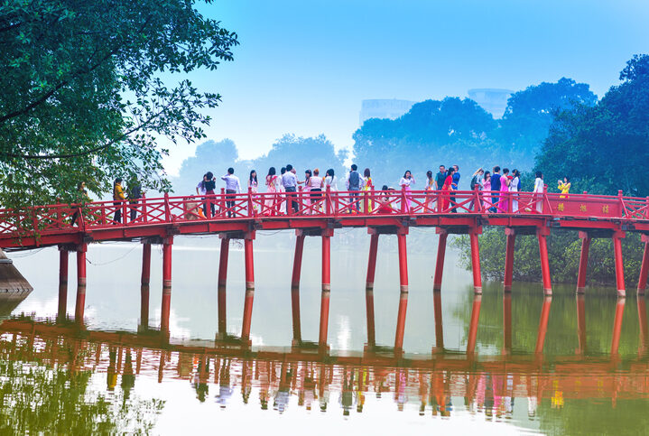 Hanoi, Vietnam-December01,2012: Huc Bridge over the Hoan Kiem Lake in Hanoi, Vietnam. The wooden red-painted bridge connects the shore and the Jade Island on which Ngoc Son Temple stands